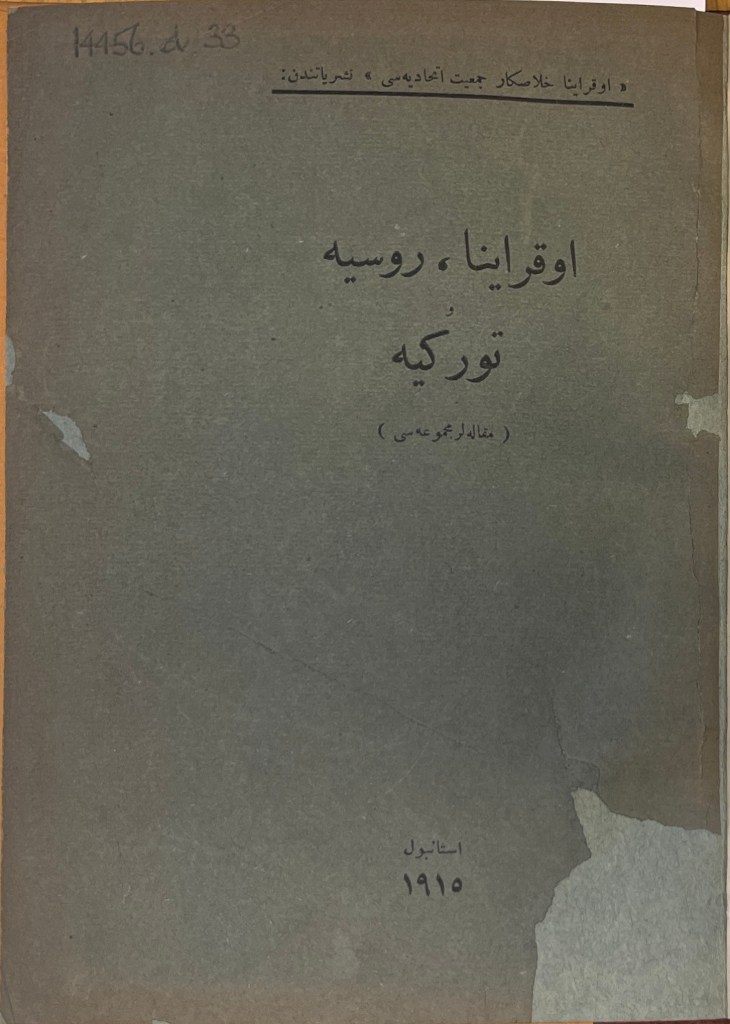 An olive-grey book cover approximately 17 centimetres in length with text in black ink in Arabic script at the top, middle and bottom of the page.