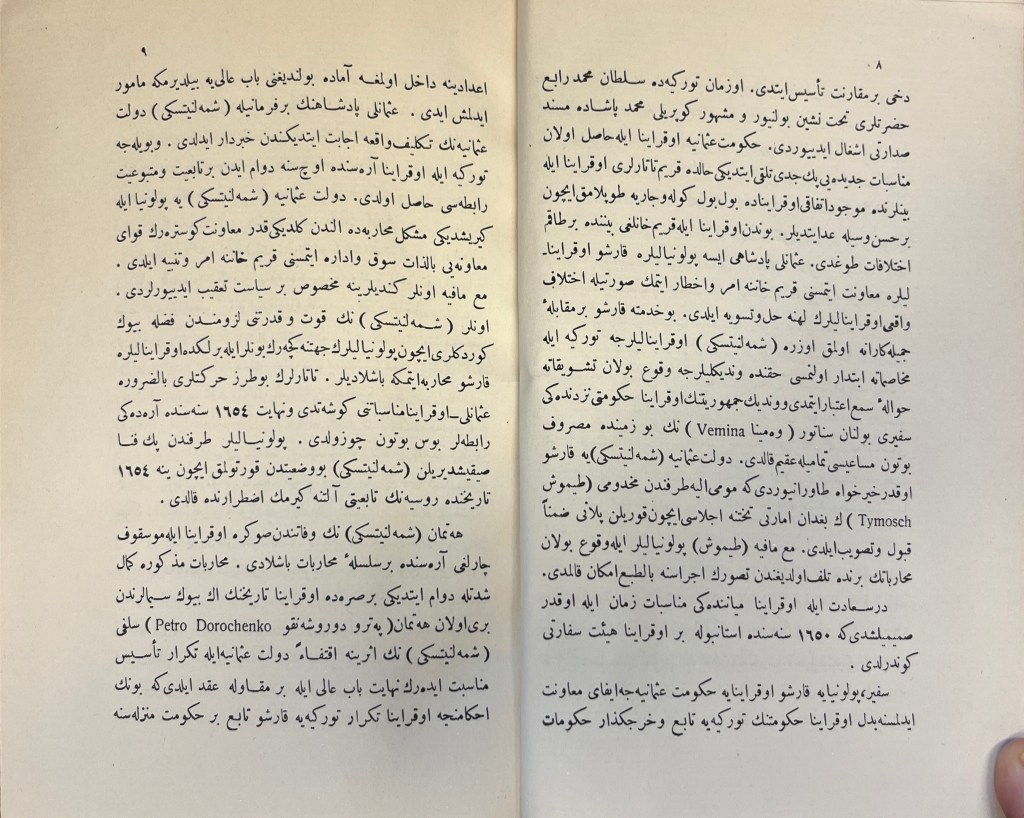 Two-page spread of white paper with black-ink text in Arabic script.