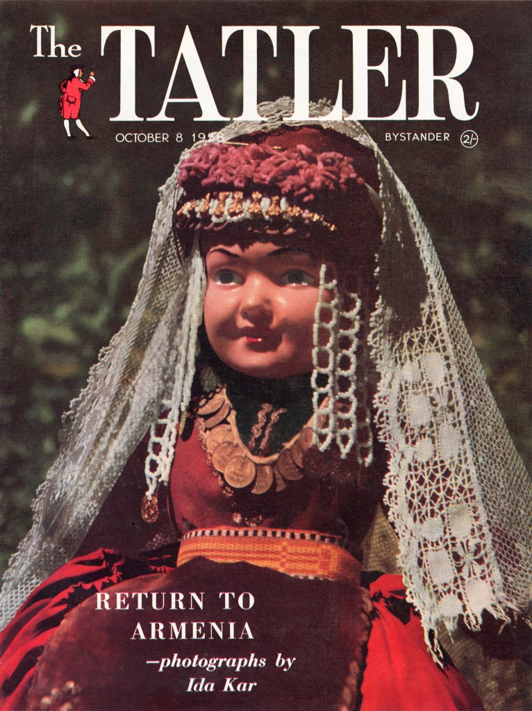 A magazine cover in colour with Latin-script text in white at the top with a doll in traditional Armenian dress in the centre of the frame.